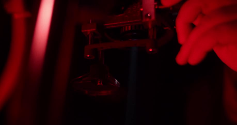 A persons hand turning a knob and adjusting a machine