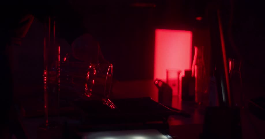 A person pours a drink down a drain in a bar