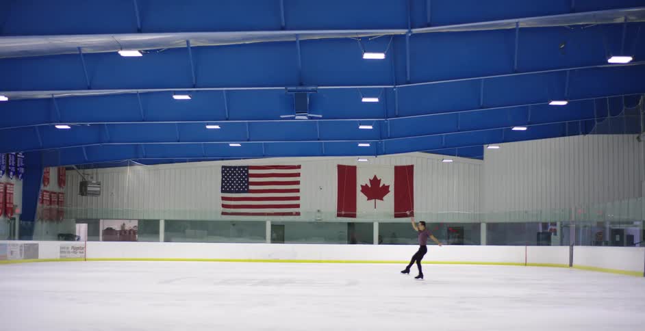 A male figure skater practicing on an ice rink