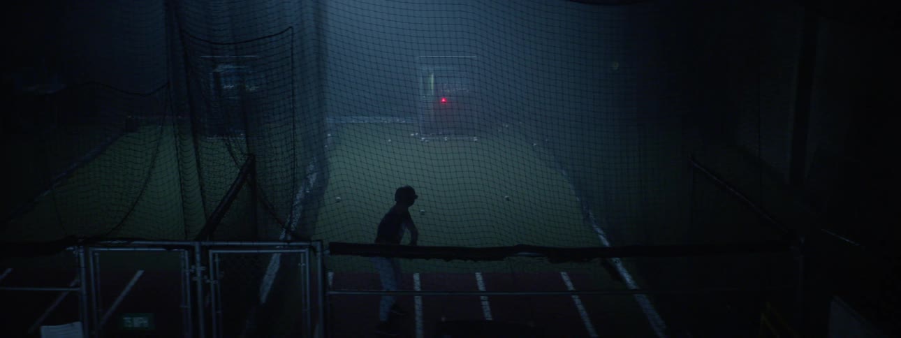 Batter practices in batting cage near net