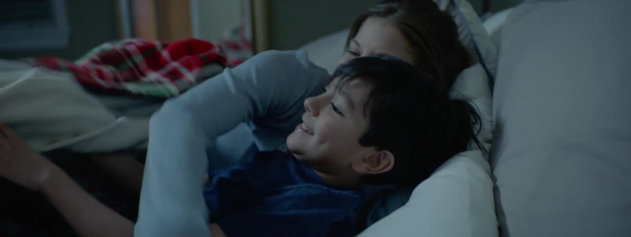 A little boy goes running in to his moms room and jumps in bed with her