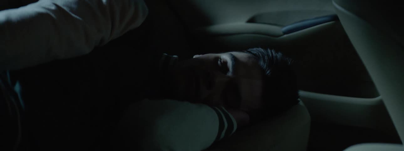 Man sleeps on the backseat of a vehicle as it travels