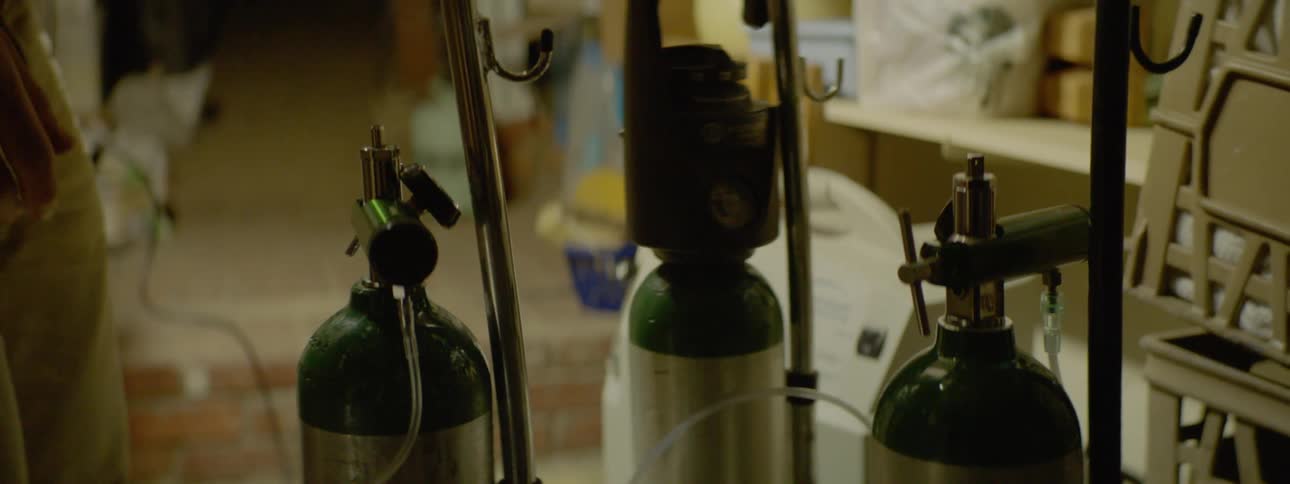 A young man turns knobs on oxygen tanks