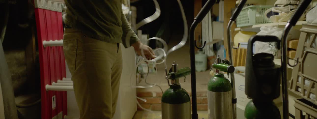 A man attaching a tube to an oxygen tank