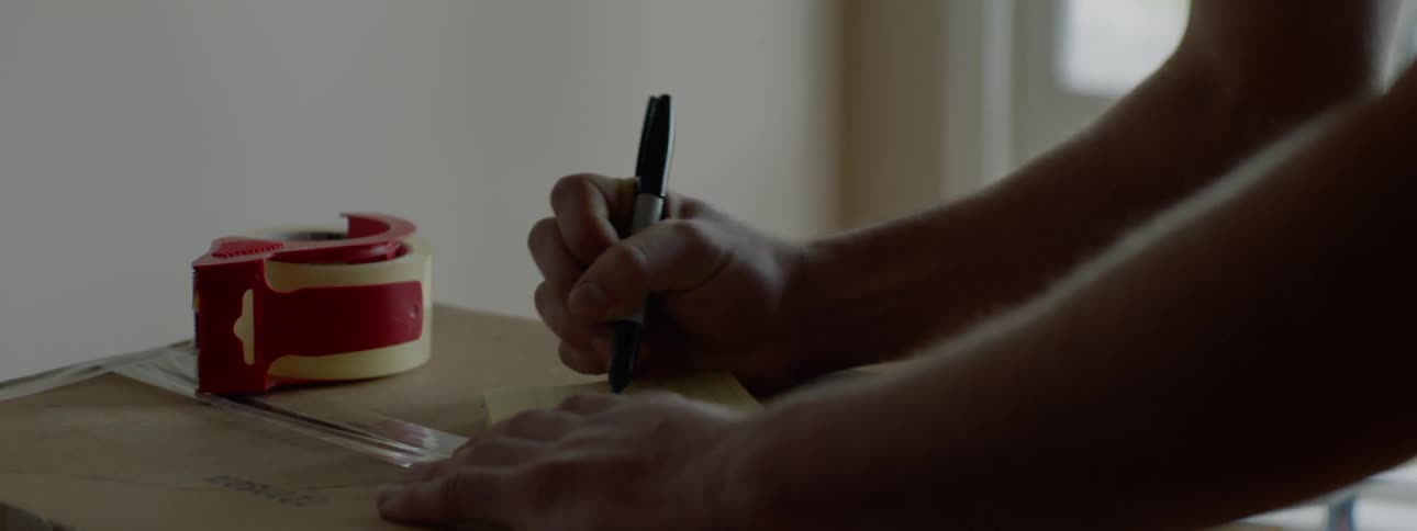 A man writes a note inside his house