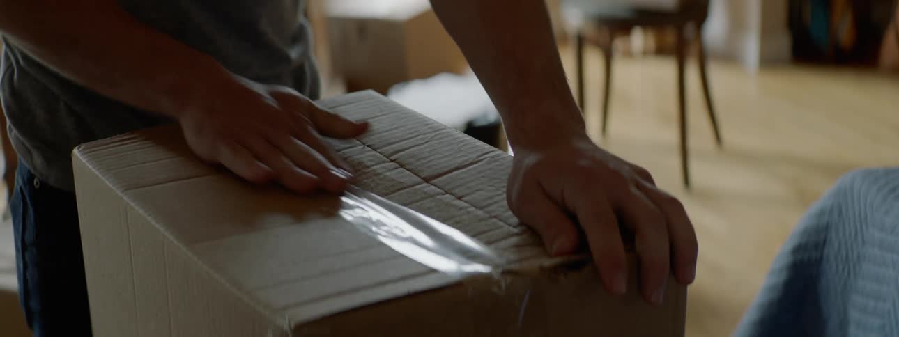 Taping a cardboard box with packing tape
