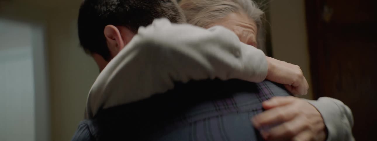 A woman on oxygen hugs her son in the kitchen