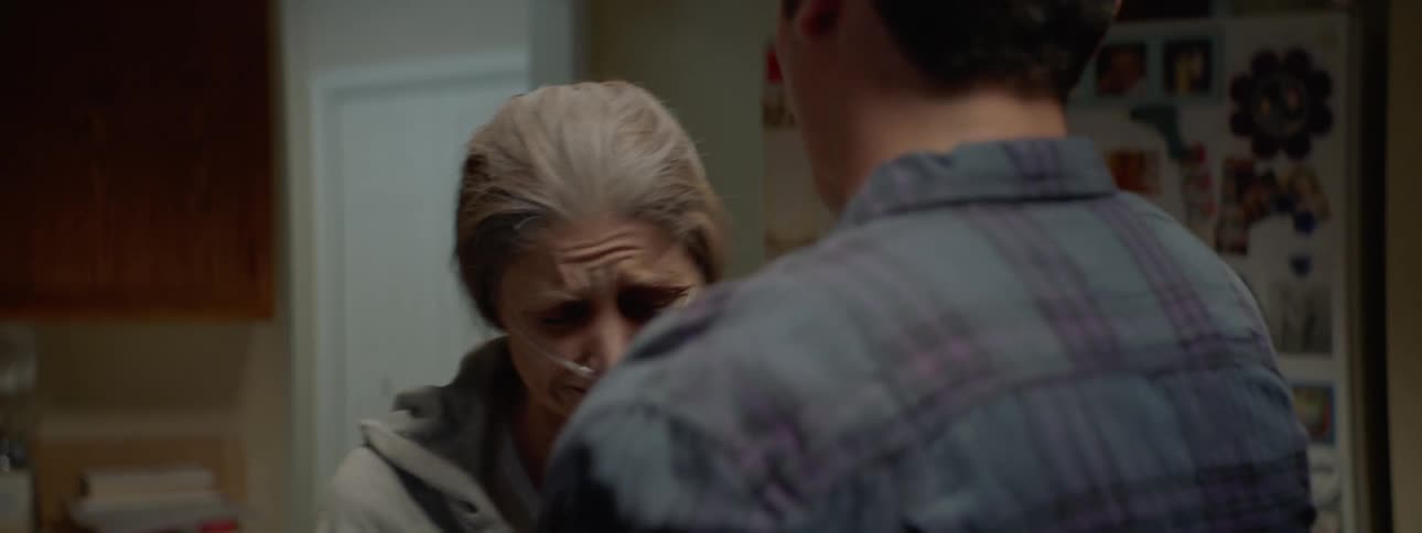 A woman hooked up to oxygen in her home cries and hugs her son
