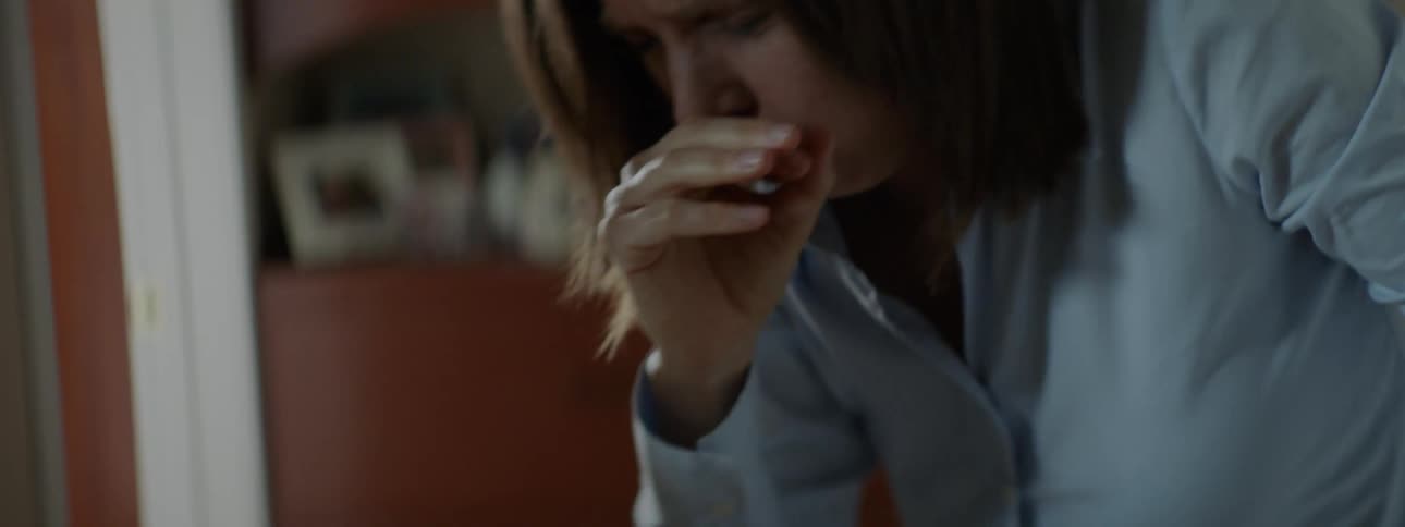 A white woman suffers a coughing fit inside a home
