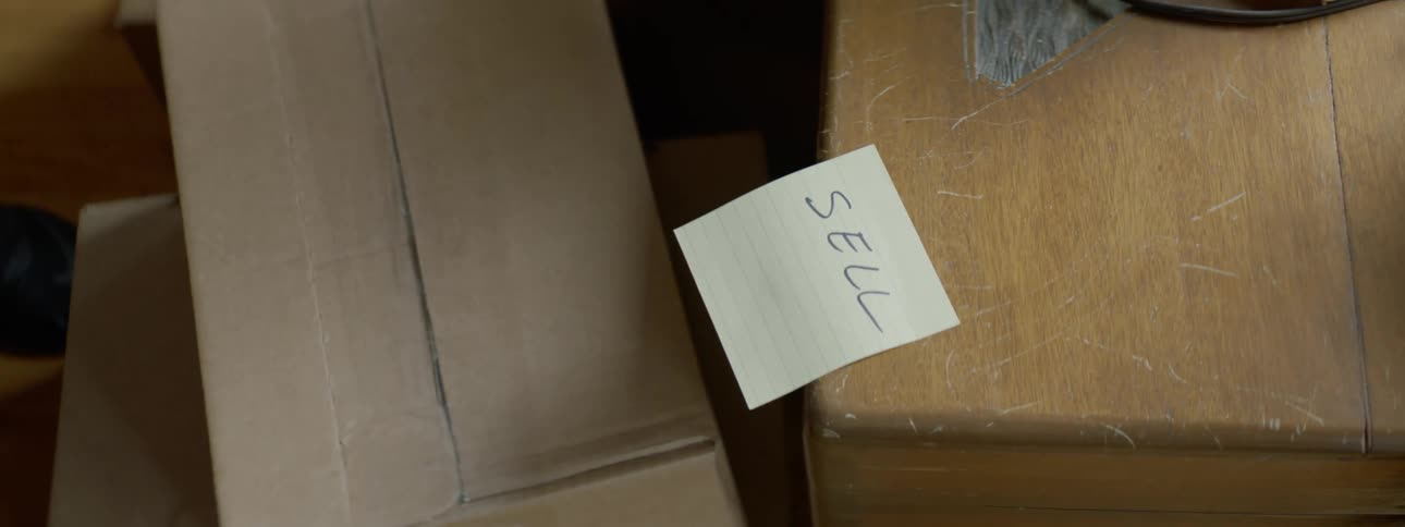 A person puts a note on a table at a neighborhood sale
