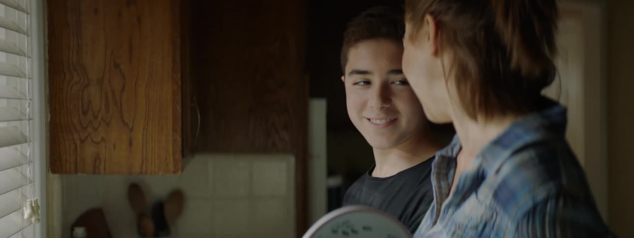 A mother and son are washing dishes together