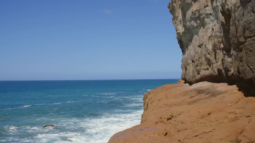 Waves rolling in to a cliff on the shore