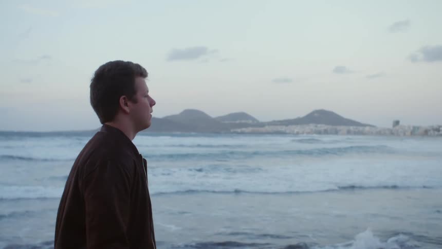 A teen walks along the coast