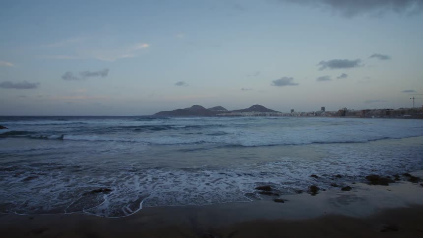 The waves move over the sand on the shore