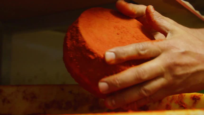 A woman pats crumbs off a mini cake