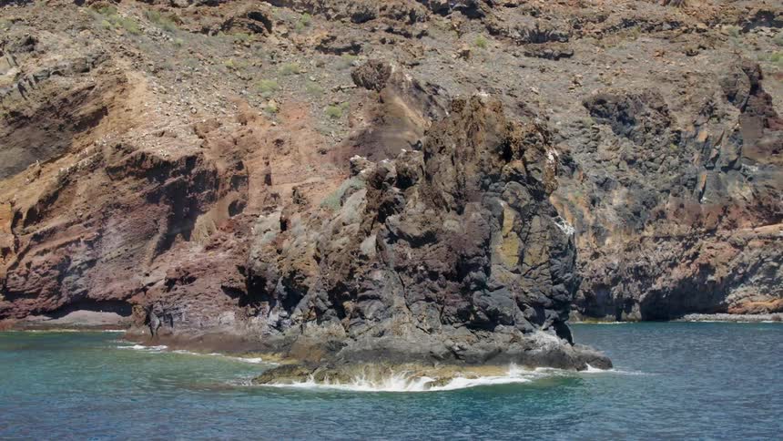 The water splashes off the rocks near the shore