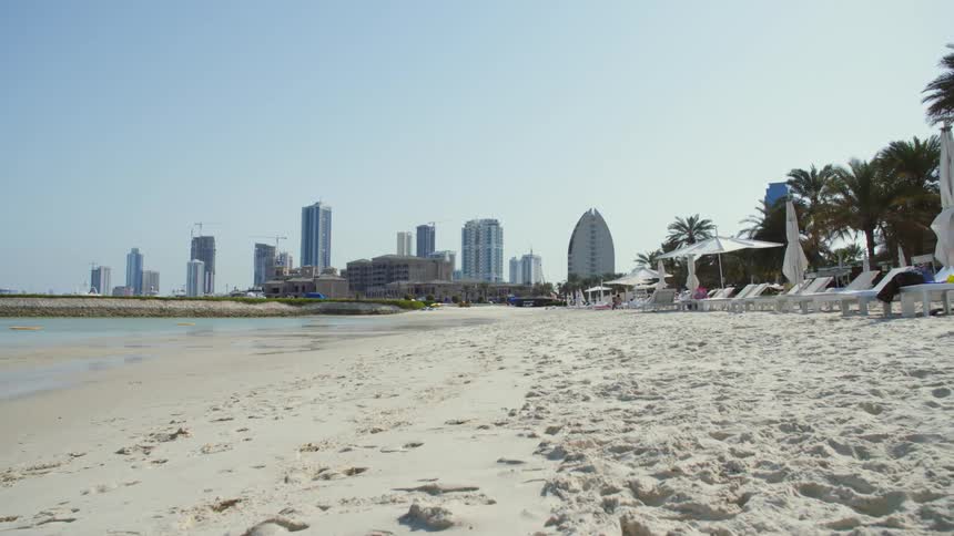 White sand beach with city skyline in the background