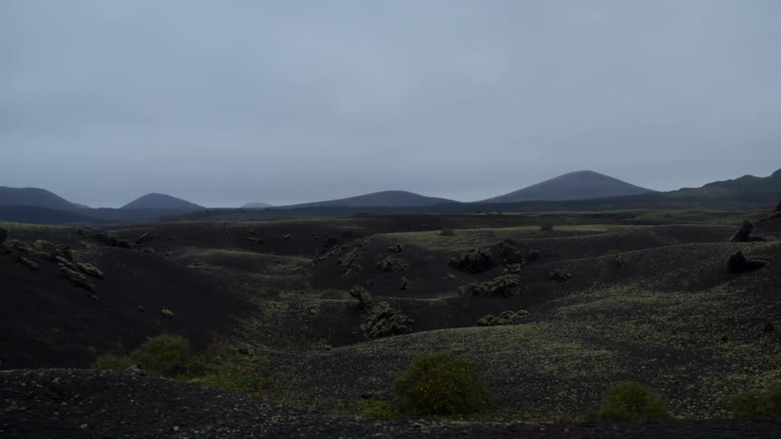 Hills and mountains sit under a cloudy sky
