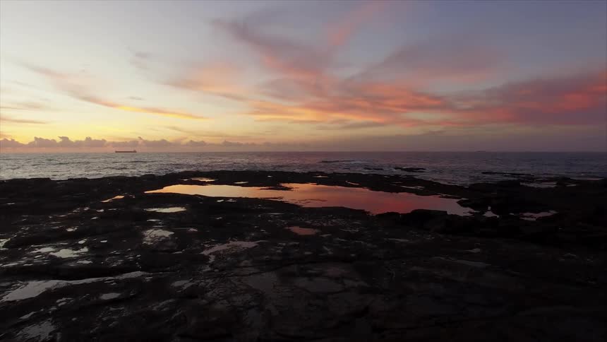 The sun sets over the ocean and coast