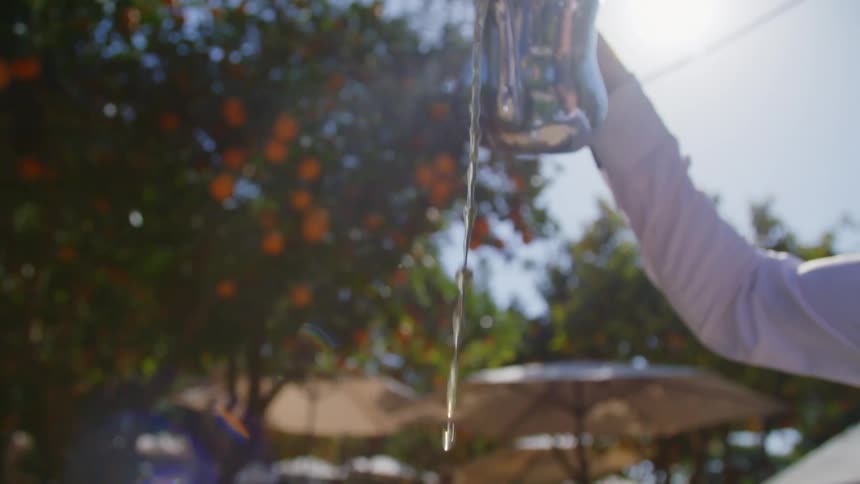 A person pours tea at an outdoor restaurant