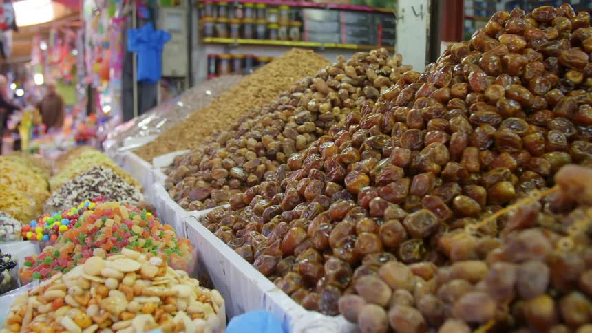 Bins of candy and nuts sit in an outdoor market