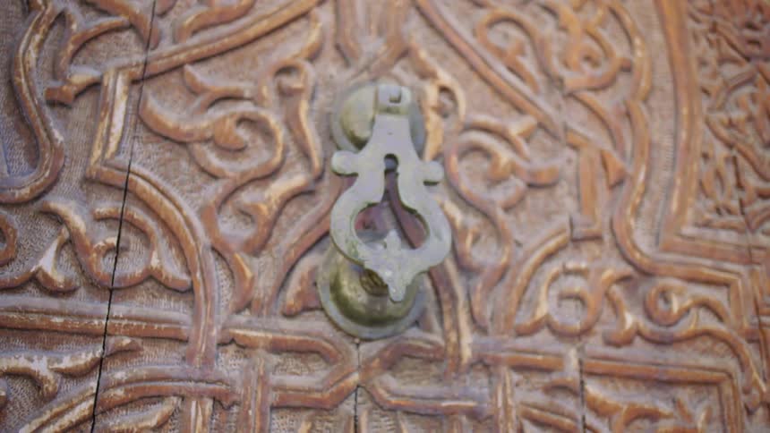 Brass door knocker on an intricate designed door