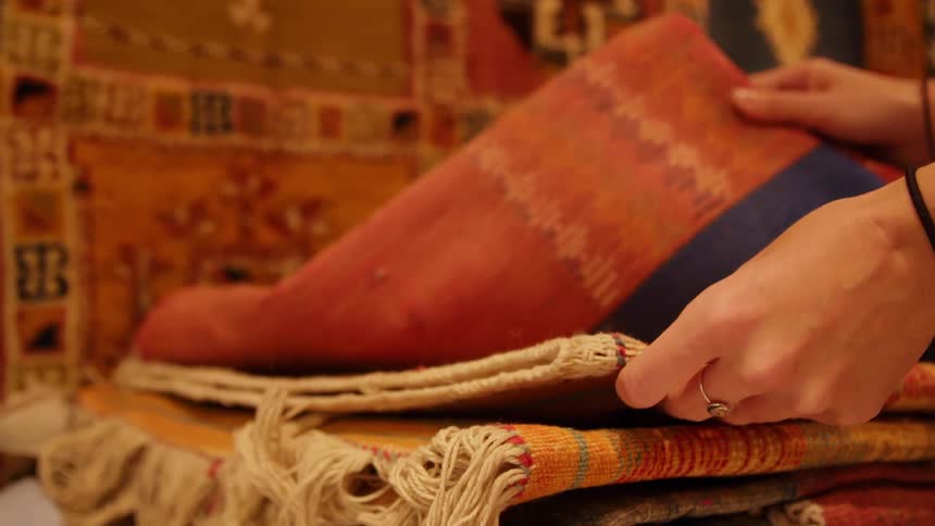 Looking through folded rugs at a local market