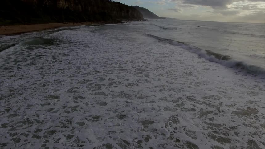 Ocean wave wash towards a sandy beach