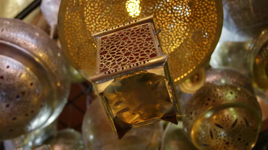 A lantern with an ornate design hangs from a metal hood