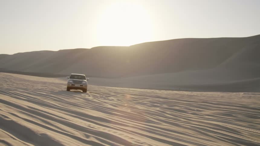 A car is driving on a dirt road