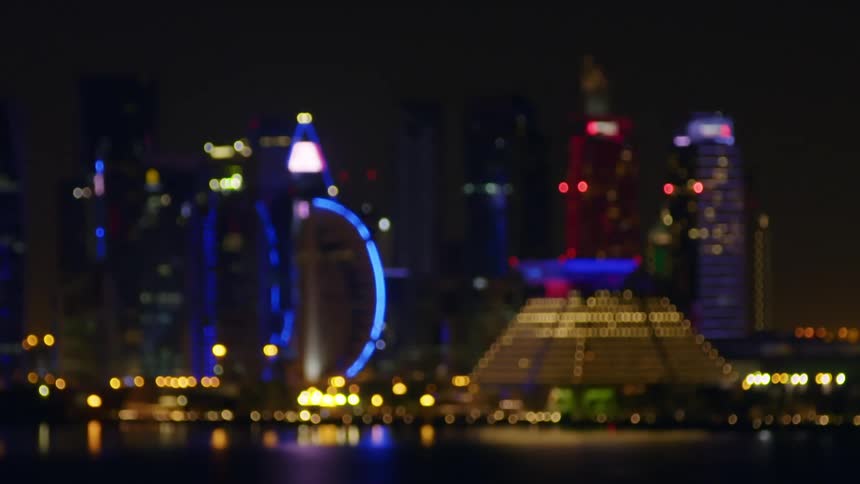 Skyscrapers illuminated by colorful and blinking lights in a metropolis at night