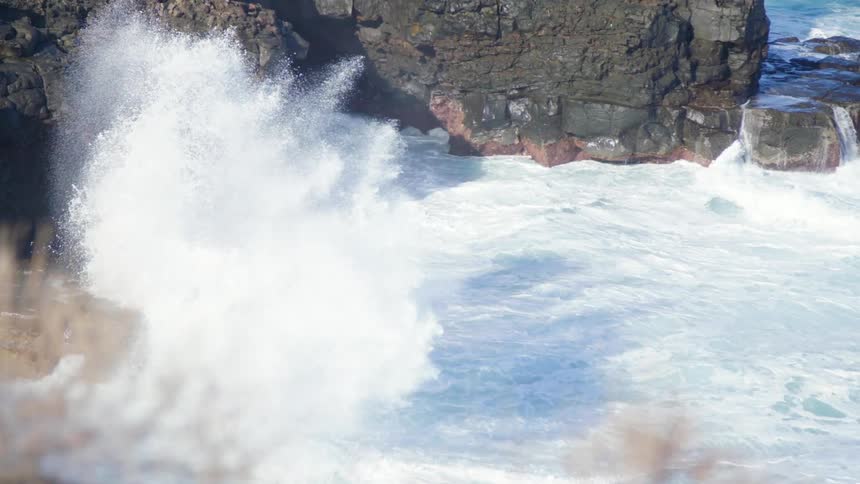 Sea waves break against a rocky shore
