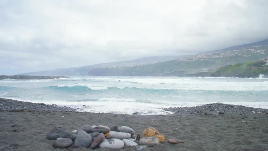 Foamy waves break on the shore on a cloudy day