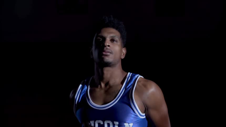A black teenager shoots a basketball