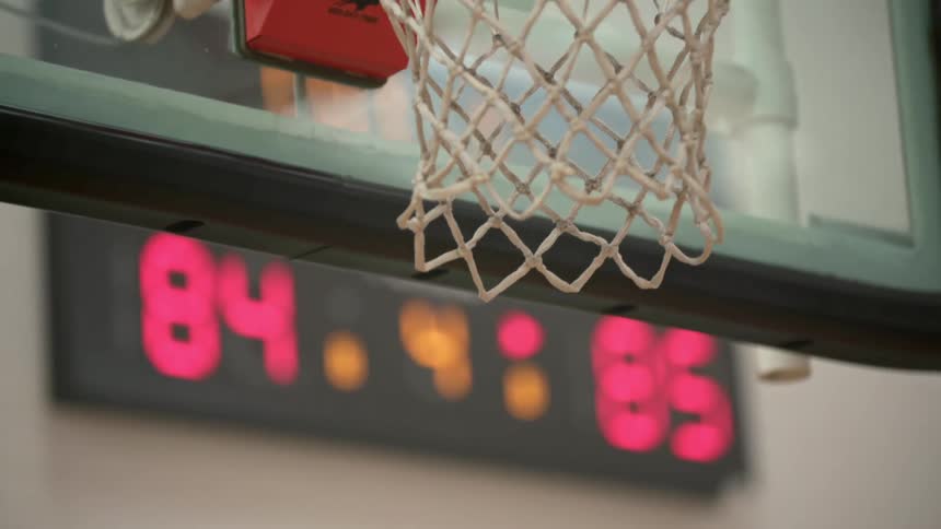 A basketball shooting through a basketball net and hoop
