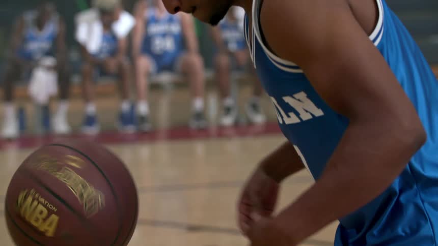 Basketball player dribbles basketball on the court