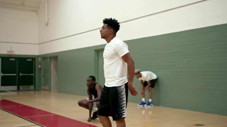 Three black male teenagers in a gymnasium