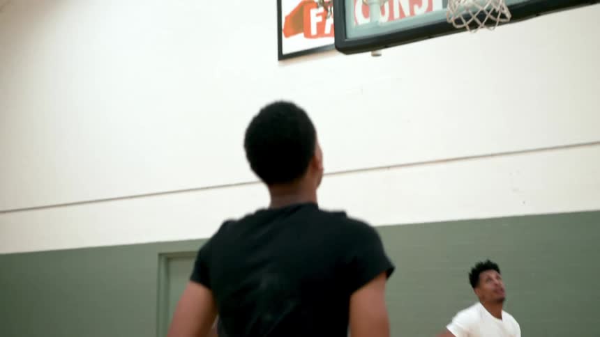 A basketball player runs down the court and shoots and scores