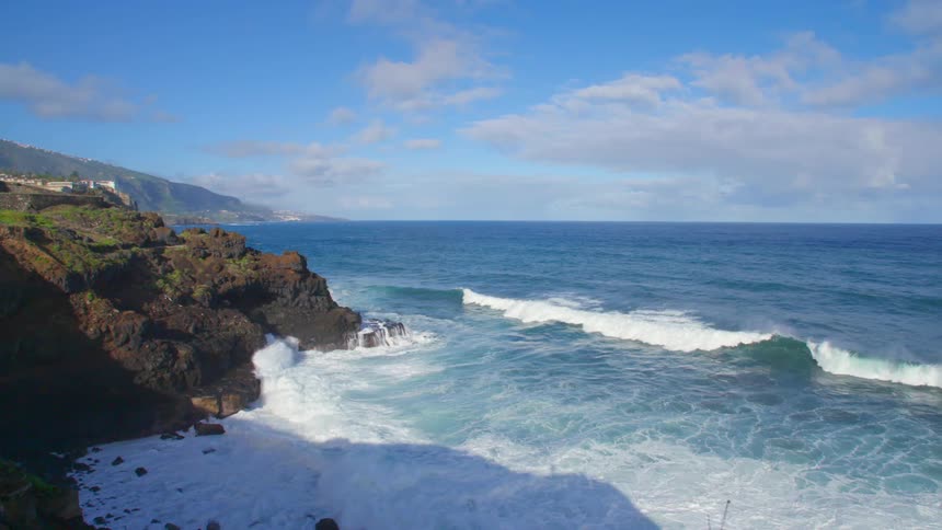 A rocky coast with waves and the sky in the background