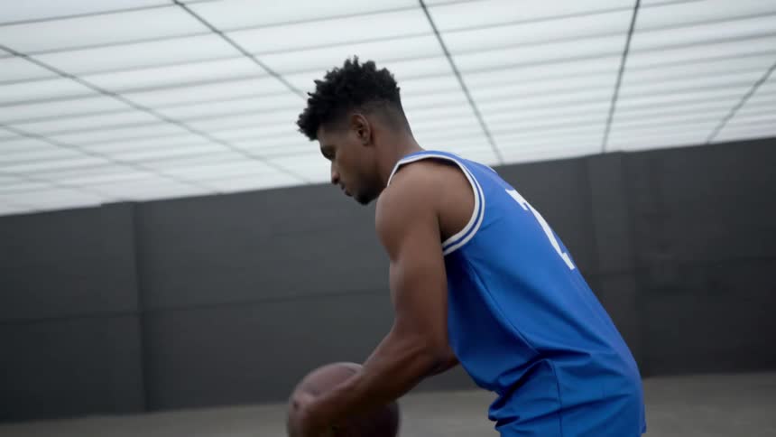 A teenager dribbles a basketball and takes a deep breath
