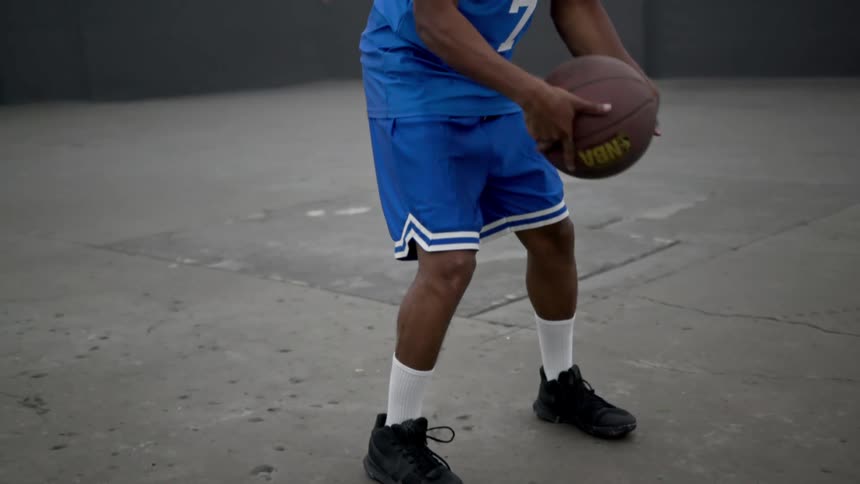 A basketball player is dribbling the ball