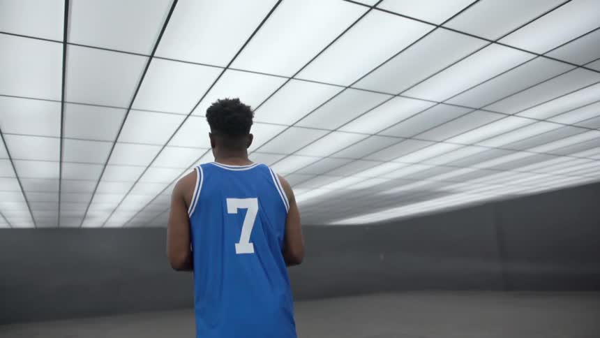 A man is playing basketball in a room