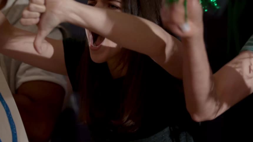 Young woman in a crowd watching an event yells and booes