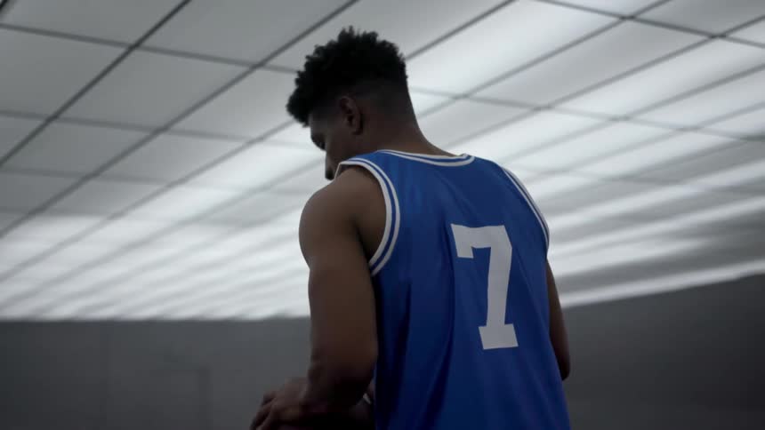 A man is dribbling the basketball alone
