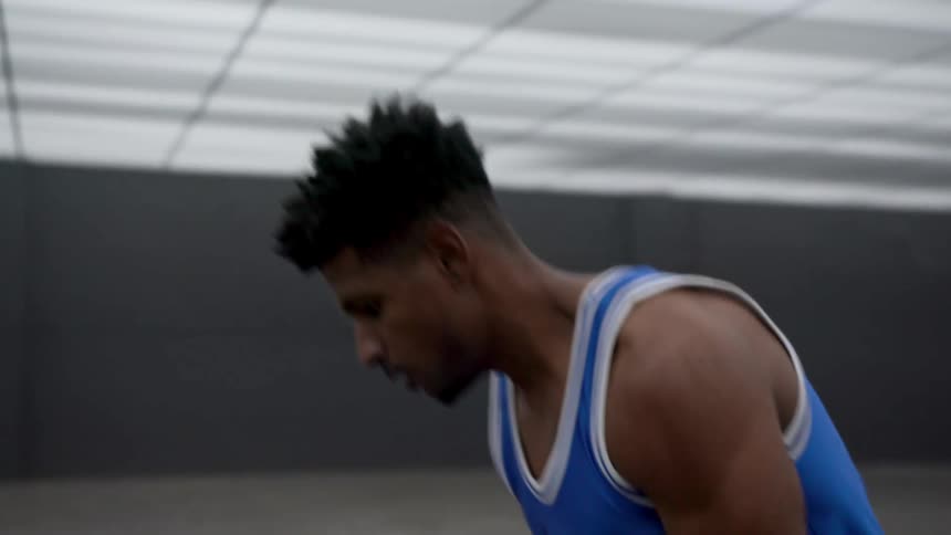 A man is dribbling the basketball around the room