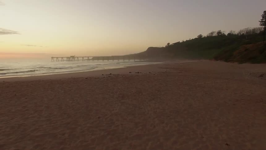 Moving over a beach at sunset