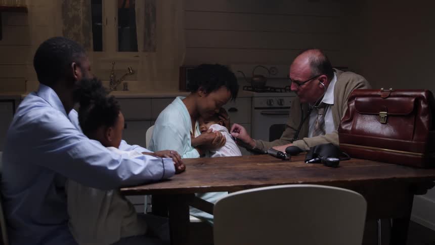 Doctor visits family at home to check on the baby