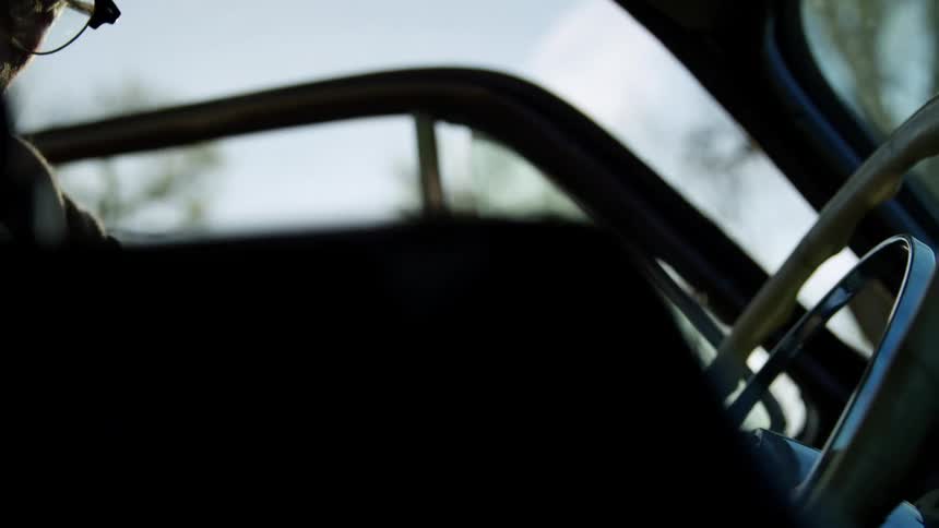 Man gets into drivers seat placing briefcase on passenger side