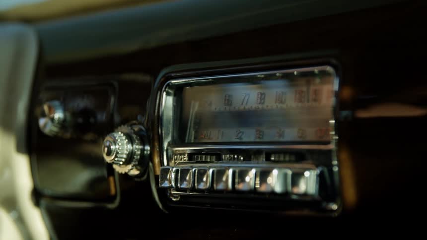 Old school vintage radio on the dashboard of a car