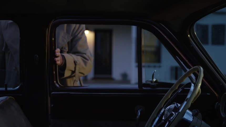 A man gets out of his car and walks home